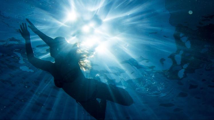 ARCHIV - Ein Frau schwimmt bei strahlendem Sonnenschein. Foto: picture alliance/Axel Heimken/dpa/Symbolbild