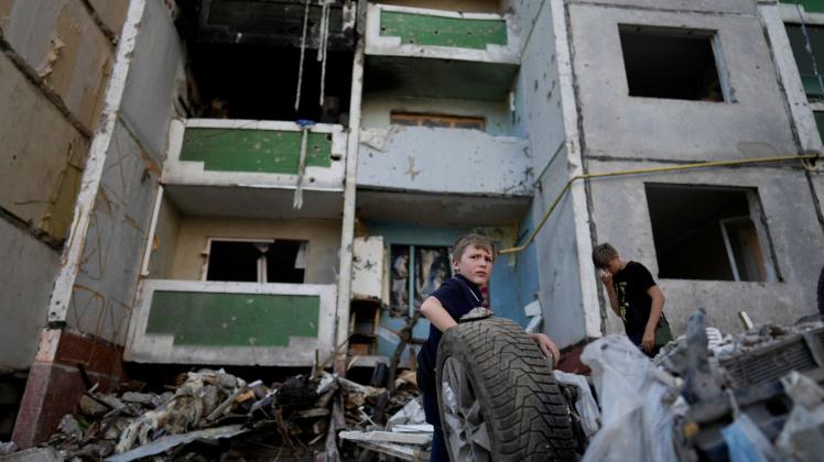 ARCHIV - Zwei Jungen stehen in den Trümmern eines zerstörten Gebäudes in Tschernihiw. Foto: Natacha Pisarenko/AP/dpa