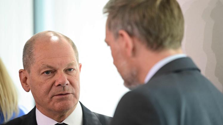 German Chancellor Olaf Scholz (L) speaks to German Finance Minister Christian Lindner prior to the start of the weekly cabinet meeting on June 22, 2022 at the Chancellery in Berlin. (Photo by John MACDOUGALL / AFP)