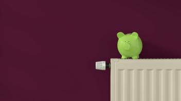 Flat radiator with green piggy bank in a burgundy room. Energy saving concept., space for your text, Stop the consumptio