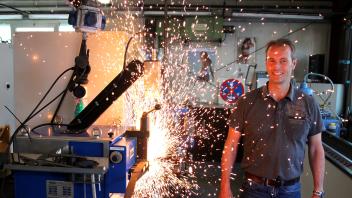 Schneidwerkzeugmechanikermeister Oliver Bohn an einem Stumpfabbrennschweißautomaten, mit dem die Enden eines passend abgeschnittenen Bandsägeblattes miteinander verschweißt werden.