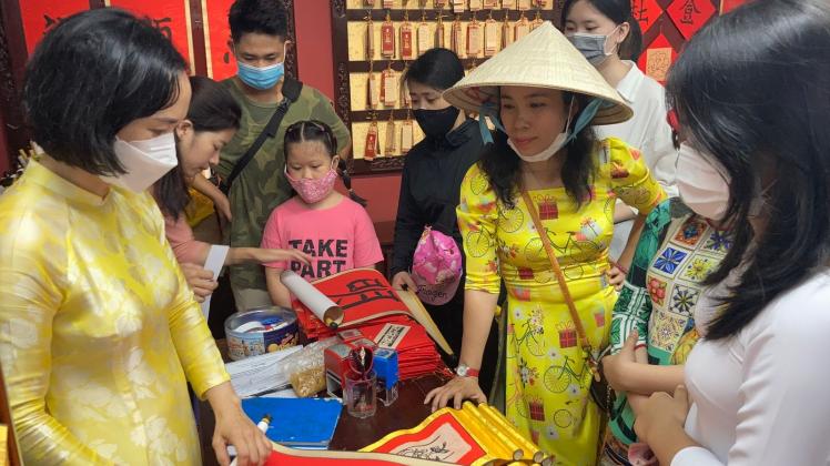 PRODUKTION - In einem Verkaufsladen in Vietnams ältester Elite-Universität werden knallrote Wandbehänge angeboten, auf die glückverheißende chinesische Schriftzeichen aufgemalt werden. Foto: Carola Frentzen/dpa