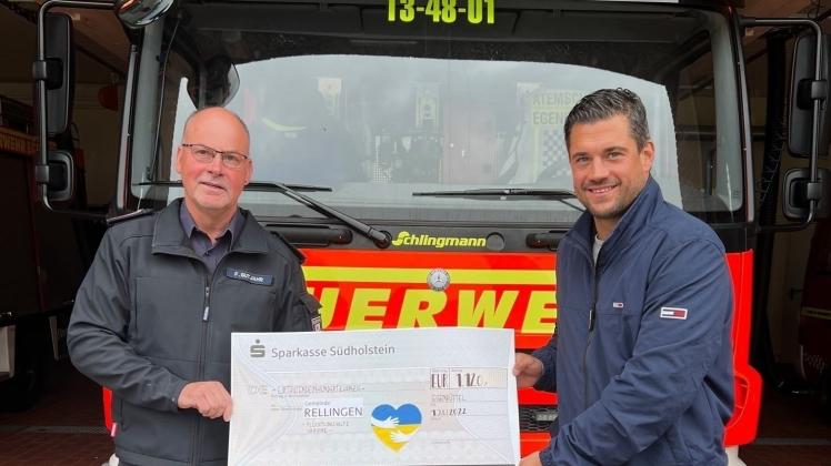 Frank Gutjahr (Ortswehrführer der Freiwilligen Feuerwehr Egenbüttel) übergibt Marc Trampe (Bürgermeister der Gemeinde Rellingen) den Spendenscheck.