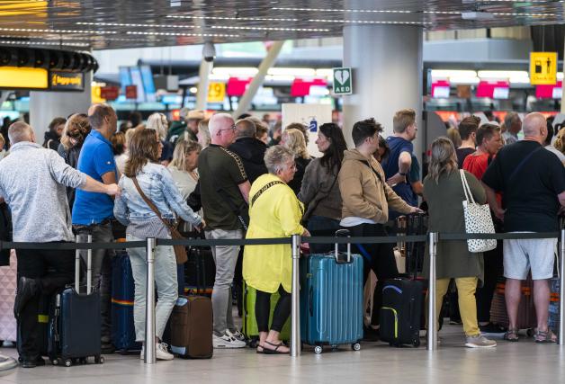 Reisende stehen in der Abflughalle des Flughafens Schiphol Schlange. Am niederländischen Flughafen Schiphol ist Chaos in diesem Sommer fast Alltag.