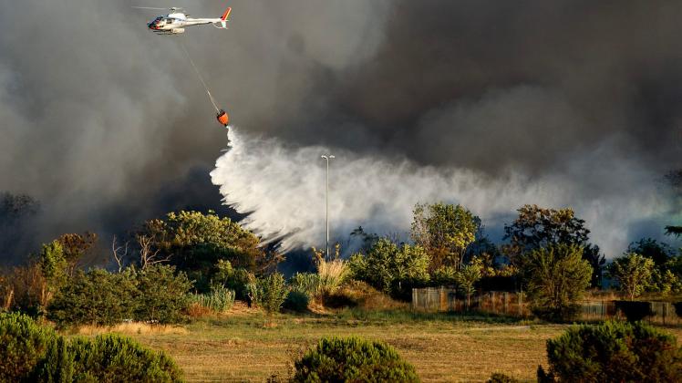 Ein Hubschrauber wirft Wasser ab, um ein Feuer im Centocelle-Park unweit von Rom zu löschen. Foto: Lapresse / Roberto Monaldo/LaPresse via ZUMA Press/dpa