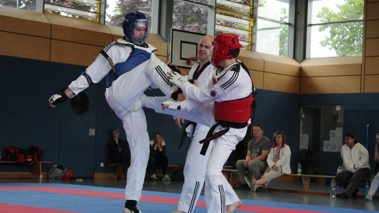 Taekwondo ist als Vollkontakt-Wettkampf mit Schutzausrüstung auch olympische Disziplin. Prüfling Waldemar Angersbach (links) kämpft unter Aufsicht von Wettkampfrichter Andre Koltermann gegen Marcel Kuhl.