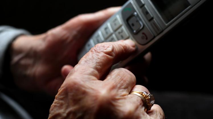 ARCHIV - Eine ältere Frau tippt auf einem schnurlosen Festnetztelefon. Foto: Karl-Josef Hildenbrand/dpa/Symbolbild