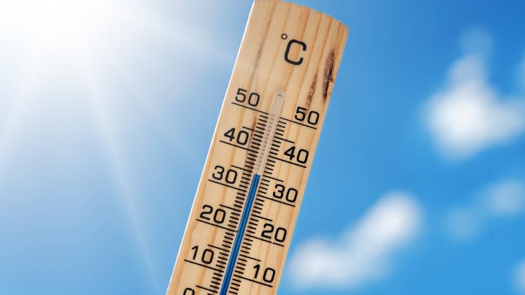23 June 2022: Wood thermometer on a hot summer day against a blue sky with sunshine, temperatures in degrees Celsius, he