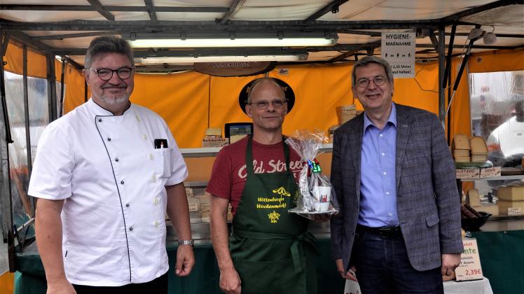 Der Vorsitzende des Wittenberger Interessenringes, Thomas Schneider (l.) und Bürgermeister Oliver Hermann (r.) begrüßen Harald Schulz auf dem Wochenmarkt. 