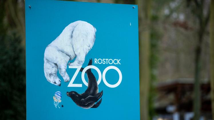 ARCHIV - Ein Schild mit dem Logo des Rostocker Zoos im Eingangsbereich des Geländes. Foto: Jens Büttner/dpa-Zentralbild/dpa/Archivbild