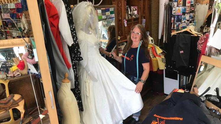 Als „Hexe Heike“ weist sich Inhaberin Heike Meyer-Schümann auf ihrem T-Shirt selbst aus. Einer ihrer Spezialitäten, das Umarbeiten von Hochzeitskleidern, führt sie am eigenen Traukleid vor.
