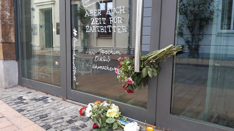 Vor dem Uhrmacherladen von Hans-Joachim Dikow in der Münzstraße haben trauernde Schweriner Blumen niedergelegt.