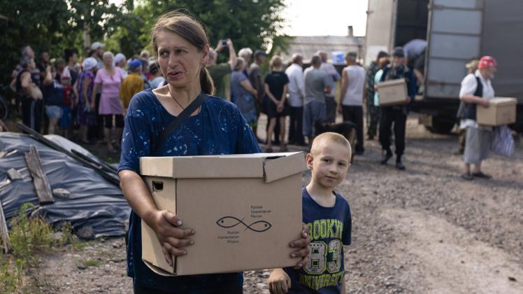 RUBIZHNE, LUGANSK PEOPLE S REPUBLIC - JULY 15, 2022: A local resident carries a box with humanitarian aid. The Russian A