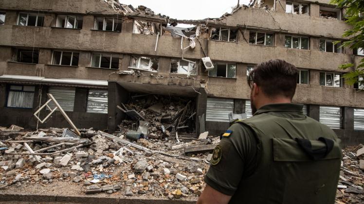 Ein ukrainischer Soldat steht vor einem zerstörten Haus in Mykolajiw. Es ist eine der am meisten angegriffenen Städte des Landes. Foto: Hector Adolfo Quintanar Perez/ZUMA Press Wire/dpa