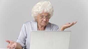 Ueberforderte Seniorin sitzt ratlos am Laptop old woman using laptop BLWS242992