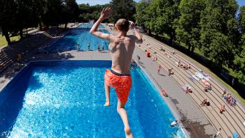 Im Kölner Stadionbad genießen Badegäste den Beginn der Freibad-Saison und springen vom Sprungturm (7,5m) ins Sprungbecke