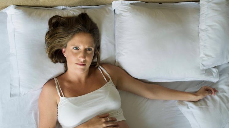 Pregnant woman lying in bed alone PUBLICATIONxINxGERxSUIxAUTxONLY Copyright: FrédéricxCirou B82187523