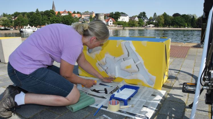Ulrike Jung bemalt einen Betonpoller am Eckernförder Hafen