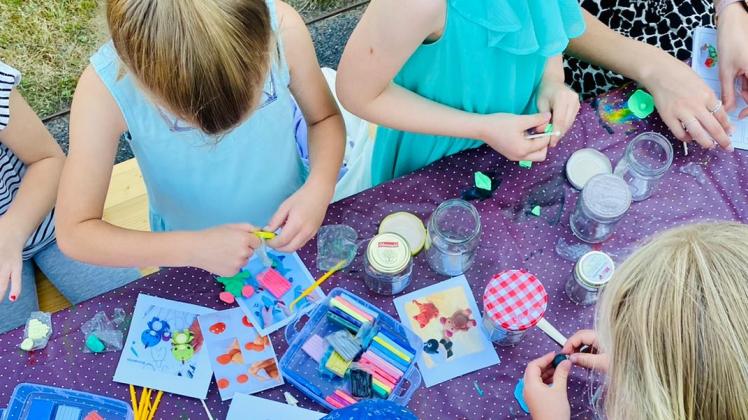 Auch Kreativangebote sind gut gebucht: Hier sind Kinder beim Basteln von Glitzerkugeln beim Ferienspaß Bissendorf.