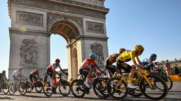 Jumbo-Visma team&apos;s Danish rider Jonas Vingegaard wearing the overall leader&apos;s yellow jersey (R) cycles with the pack of riders past the Arc de Triomphe on the Champs-Elysees during the 21st and final stage of the 109th edition of the Tour de France cycling race, 115,6 km between La Defense Arena in Nanterre, outside Paris, and the Champs-Elysees in Paris, France, on July 24, 2022. (Photo by Marco BERTORELLO / AFP); ; paris; ; france;;staging race, cycling