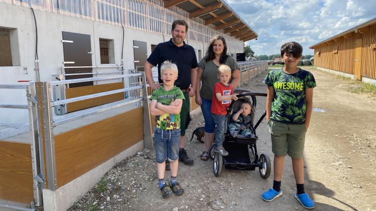 Marcel und Johanna Hackmann mit ihren Kindern Henri, Jonas, Toni und Pflegesohn Arash vor den neuen Stallungen, in die demnächst die Zuchtsauen einziehen sollen.