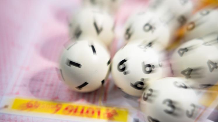 ARCHIV - Lotto-Kugeln liegen auf einem Lottoschein. Foto: Tom Weller/dpa/Symbolbild