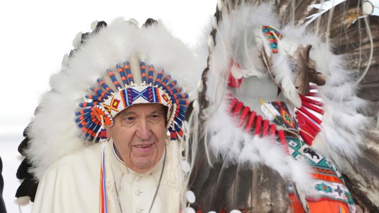 dpatopbilder - Papst Franziskus trägt einen traditionell indigenen Kopfschmuck, der ihm während einer Zeremonie überreicht wurde. Foto: Nathan Denette/The Canadian Press/AP/dpa