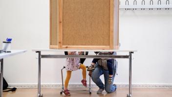 Wahlen in Deutschland Mutter mit zwei Kindern in der Wahlkabine - Deutschland waehlt - Symbolbild Wahlen in Deutschland