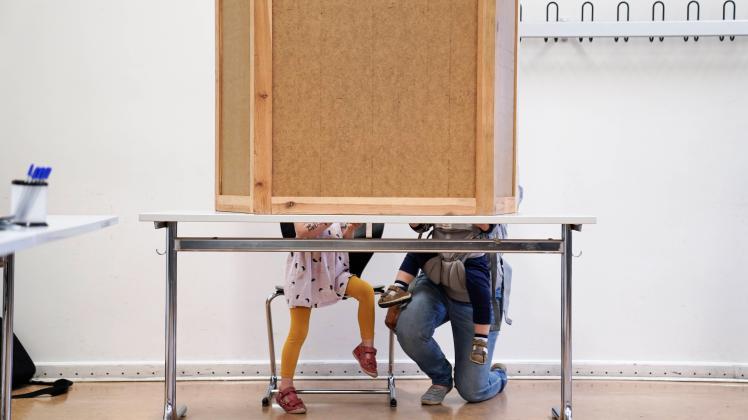 Wahlen in Deutschland Mutter mit zwei Kindern in der Wahlkabine - Deutschland waehlt - Symbolbild Wahlen in Deutschland