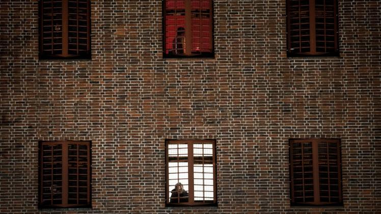ARCHIV - Ein Häftling schaut aus einem vergitterten Zellenfenster. Foto: Christian Charisius/dpa/Archivbild