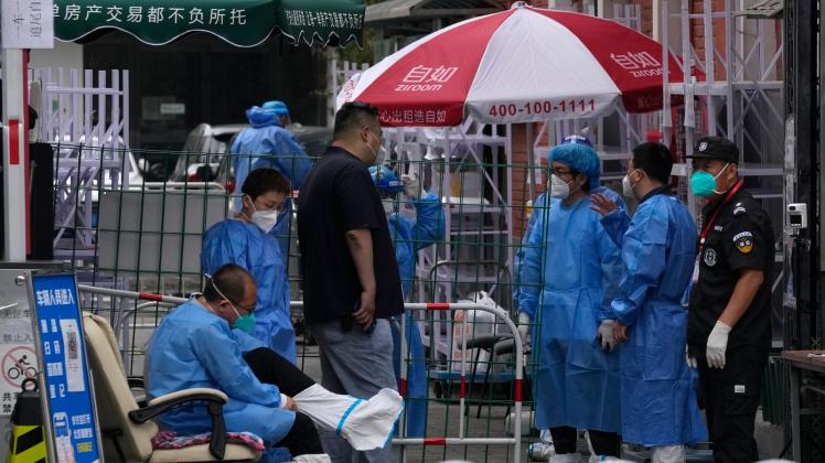 ARCHIV - Medzinisches Personal steht am Eingang einer abgeriegelten Gemeinde in Peking: Auf der Suche nach dem Ursprung des Coronavirus Sars-CoV-2 kommt Wissenschaftlern zufolge wahrscheinlich ein Markt in Wuhan in Betracht. Foto: Ng Han Guan/AP/dpa