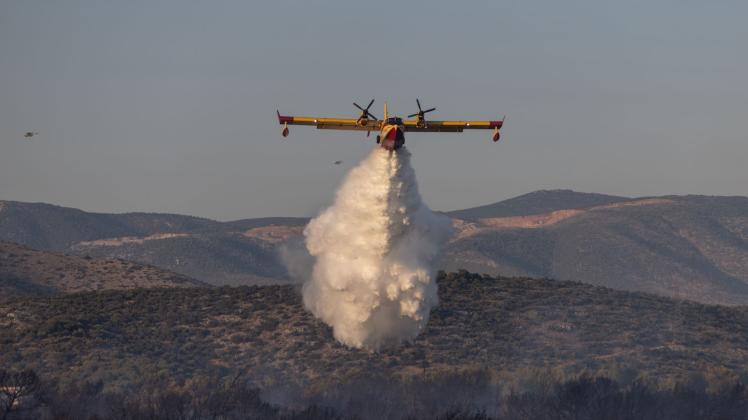 Ein Flugzeug versucht, einen Waldbrand in einem Wald in der Nähe der Stadt Mandra im Westen Attikas zu löschen. Foto: Lefteris Partsalis/XinHua/dpa