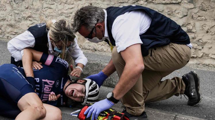 Nach ihrem Sturz wird die deutsche Fahrerin Laura Süßemilch von Sanitätern behandelt. Foto: Jeff Pachoud/AFP/dpa