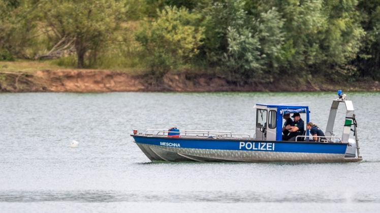 Ein Polizeiboot fährt an einer Boje vorbei. Foto: Lino Mirgeler/dpa
