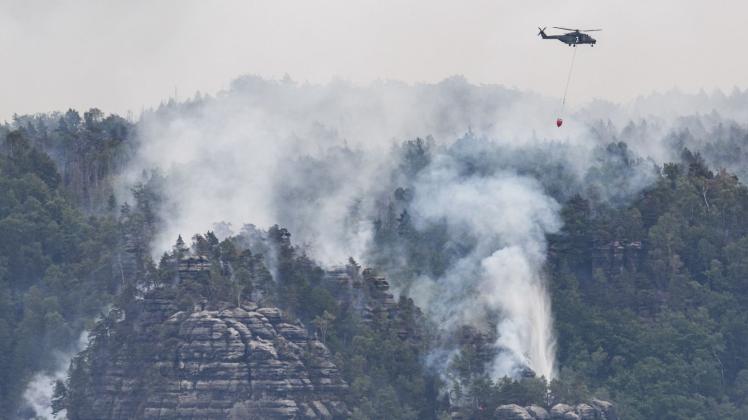 ARCHIV - Die Waldbrände werden rund um die Uhr von Löschhubschraubern überflogen. Die Lage bleibt weiterhin angespannt. Foto: Robert Michael/dpa