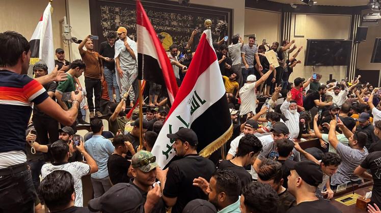 dpatopbilder - Anhänger des schiitischen Geistlichen al-Sadr stehen im irakischen Parlament. Foto: Ali Jabar/AP/dpa