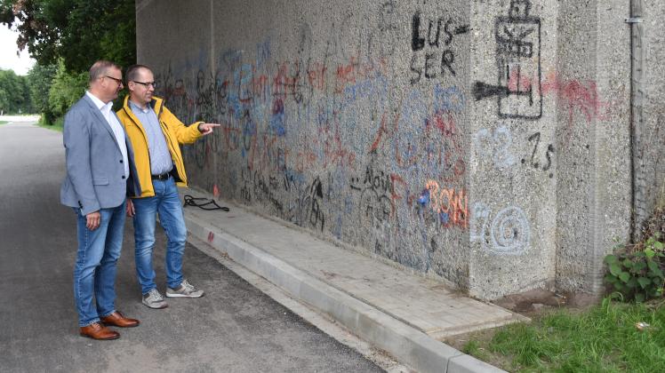 Samtgemeindebürgermeister Helmut Wilkens und Ordnungsamtsleiter Dietmar Wilkens begutachten eine der vielen Stellen, die mit Graffiti besprüht wurden.