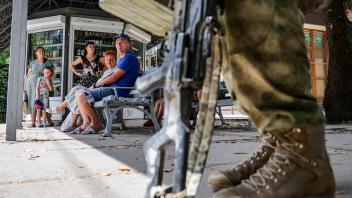Ukraine-Konflikt, Eindrücke aus Cherson  KHERSON, UKRAINE - JULY 11, 2022: A serviceman and local residents are seen in