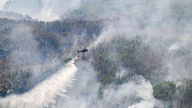 Ein Lösch-Hubschrauber der Bundespolizei über dem Waldbrand im Nationalpark Sächsische Schweiz. Foto: Robert Michael/dpa