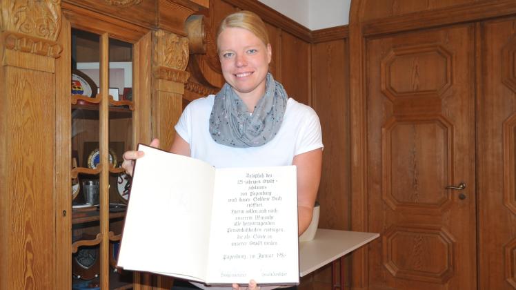 Im historischen Sitzungssaal des Rathaus hat Stadtsprecherin Karin Evering das Goldene Buch der Stadt Papenburg aufgeschlagen.