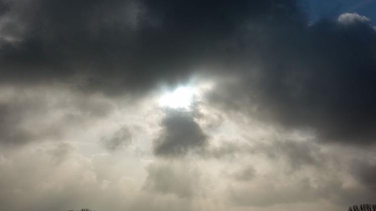 ARCHIV - Die Sonne kommt nur kurzzeitig hinter einer dunklen Wolkendecke hervor. Foto: Jens Kalaene/dpa-Zentralbild/ZB/Symbolbild