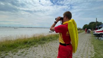 Der 17-jährige Wasserretter Björn Lesle hält Ausschau mit dem Fernglas, denn das Baden in der Elbe sei sehr gefährlich.