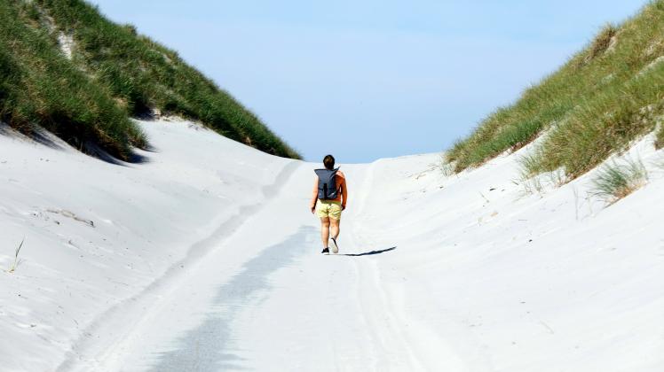 Amrum - Touristen nach Corona Lockerungen wieder da Eine Frau geht zum Strand auf der Insel Amrum. In Schleswig-Holstein