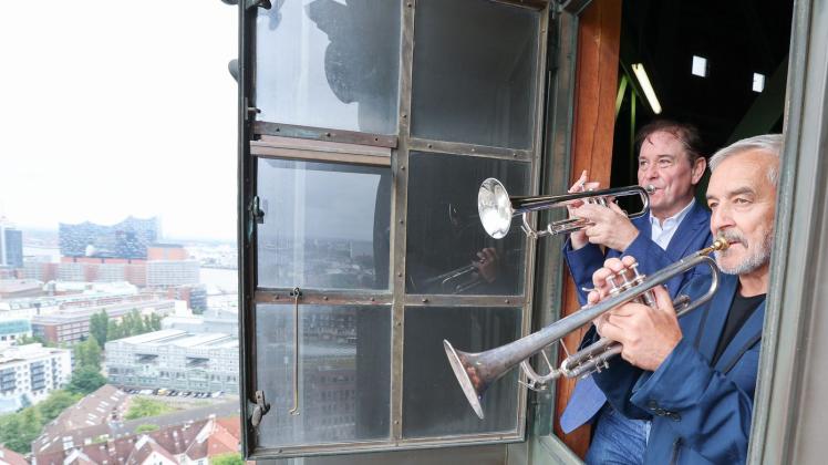 Die Hamburger Turmbläser Horst Huhn (r) und Josef Thöne stehen mit ihren Trompeten bei einem Fototermin an einem Fenster. Foto: Christian Charisius/dpa