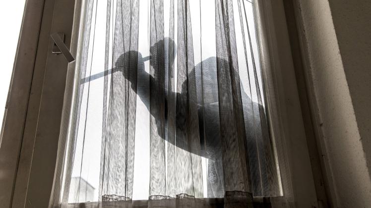 Symbolbild Wohnungseinbruch Täter versucht in eine Wohnung einzubrechen hebelt ein Fenster mit Wer