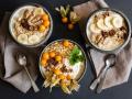 Three bowls of porridge with oats, flax seed, winter cherries and bananas EVGF03768