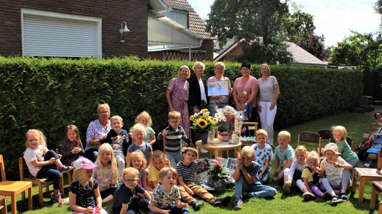 Im Kreis der Kolleginnen und der Kinder von der Regenbogen-Gruppe: Seit 25 Jahren arbeitet Tanja Thale (mit Bilderrahmen) in der Kindertagesstätte St. Katharina in Fürstenau.