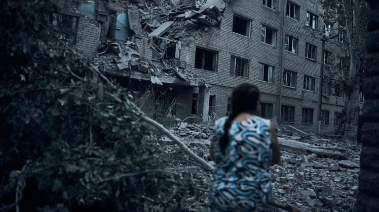 dpatopbilder - Eine Frau steht inmitten der Trümmer eines Wohnhauses in Mykolajiw, das durch russischen Beschuss zerstört wurde. Foto: Kostiantyn Liberov/AP/dpa