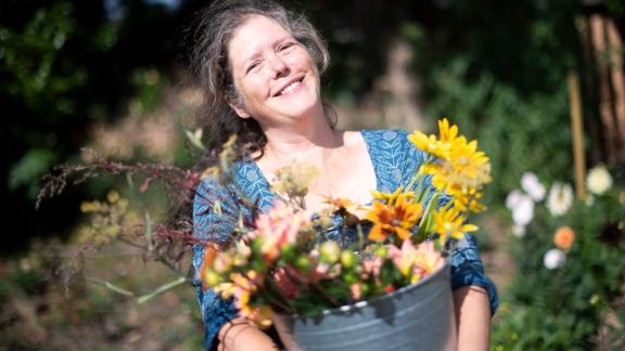 ARCHIV - Claudia Werner steht mit einem Eimer mit frisch geschnittenen Blumen in ihrem Garten. Früher arbeitete die Bremerin als Erzieherin - heute hat sie eine eigene Gärtnerei. Foto: Sina Schuldt/dpa ARCHIV - Claudia Werner steht mit einem Eimer mit frisch geschnittenen Blumen in ihrem Garten. Früher arbeitete die Bremerin als Erzieherin - heute hat sie eine eigene Gärtnerei. Foto: Sina Schuldt/dpa