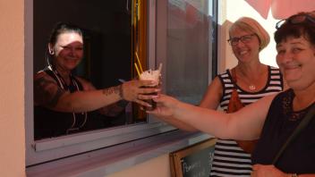 Verkäuferin Sarah Sonnenberg überreicht Heike Biermann und Birgit Fischer (r.) die bestellten Eiskaffees. 